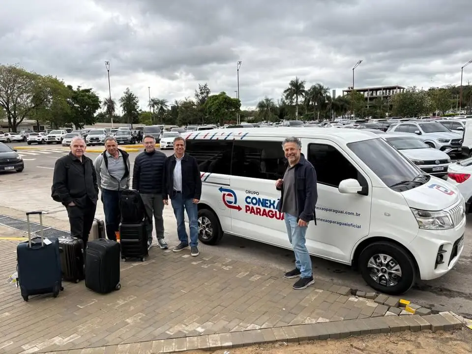 Cinco viajantes ao lado de uma van da Conexão Paraguai